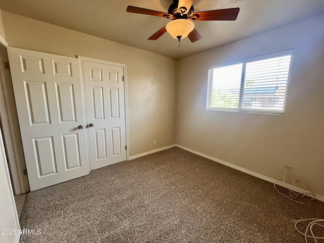 unfurnished bedroom with carpet, baseboards, ceiling fan, and a closet