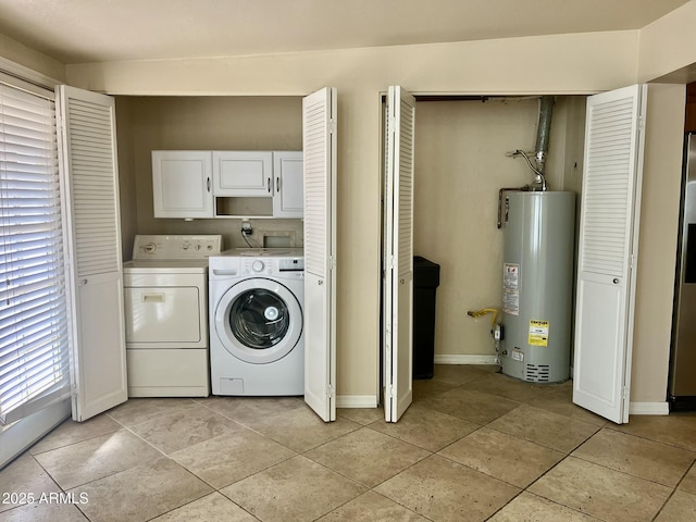 washroom featuring light tile patterned floors, baseboards, water heater, cabinet space, and washer and clothes dryer