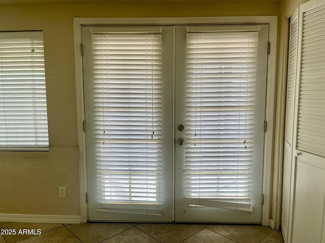 doorway with baseboards, a healthy amount of sunlight, and tile patterned floors