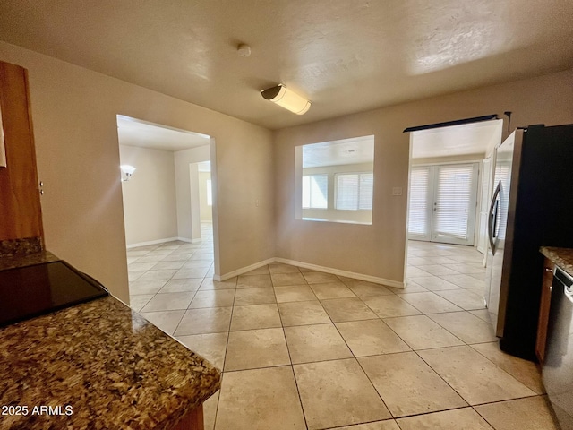 interior space featuring baseboards and light tile patterned floors