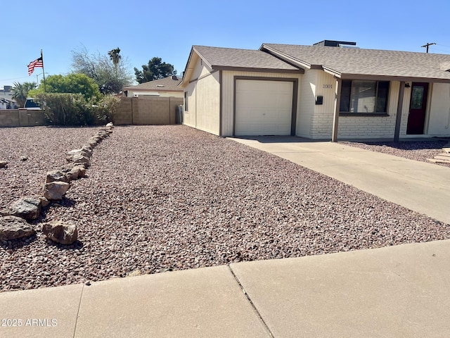 single story home with a shingled roof, concrete driveway, fence, and an attached garage