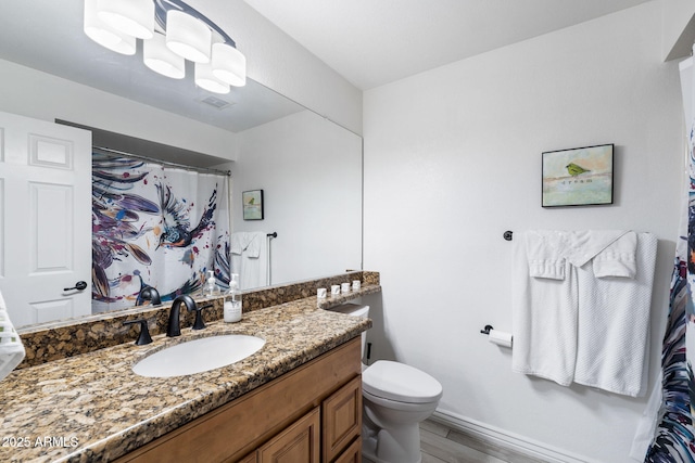 bathroom featuring vanity, wood-type flooring, and toilet