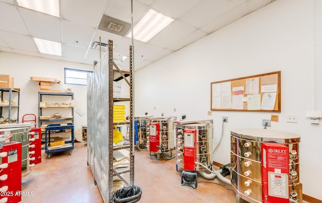 miscellaneous room with concrete flooring and a drop ceiling