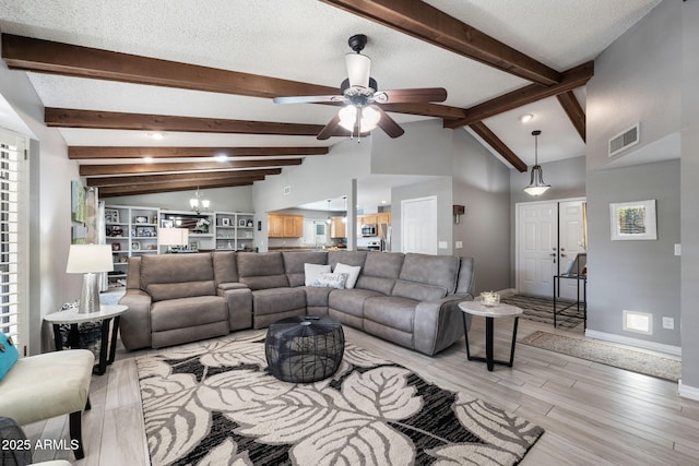 living room with lofted ceiling with beams, a textured ceiling, and light wood-type flooring