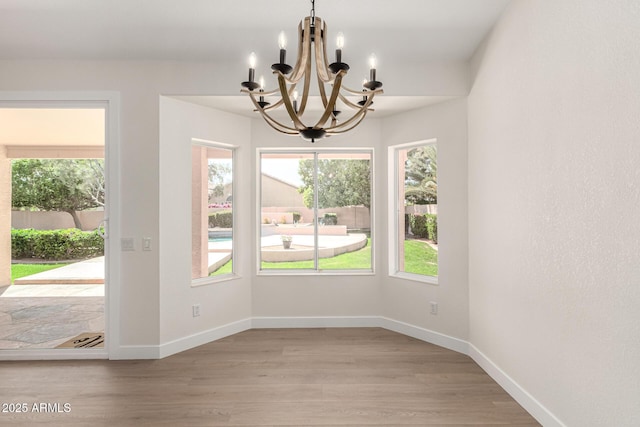 4010 N 156th Ln, Goodyear, AZ 85395 - unfurnished dining area featuring a chandelier, baseboards, and wood finished floors