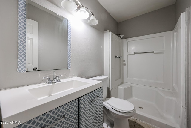 bathroom with a stall shower, toilet, and vanity