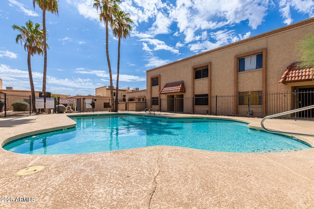 community pool featuring a patio area and fence