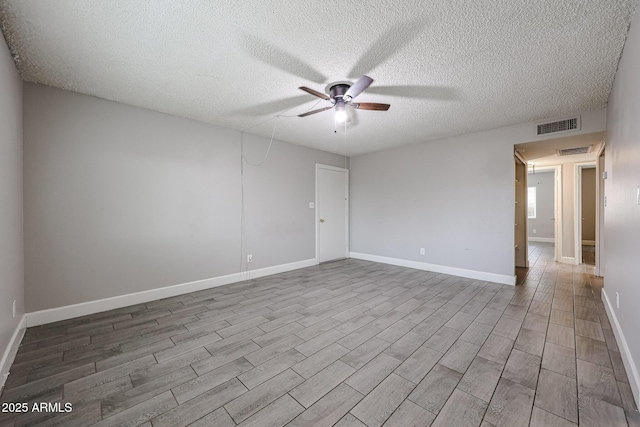 unfurnished room featuring baseboards, wood finished floors, visible vents, and ceiling fan