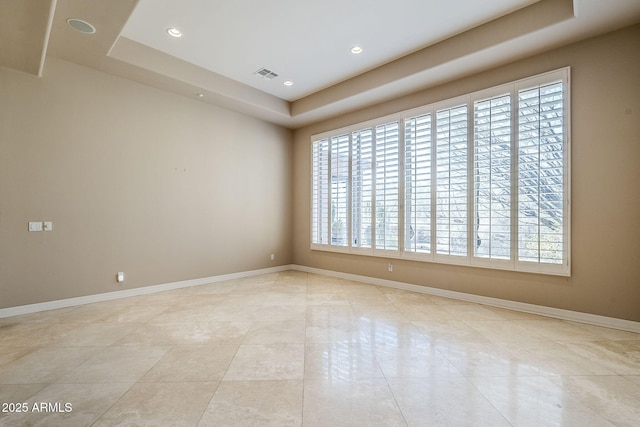 empty room with plenty of natural light and a raised ceiling