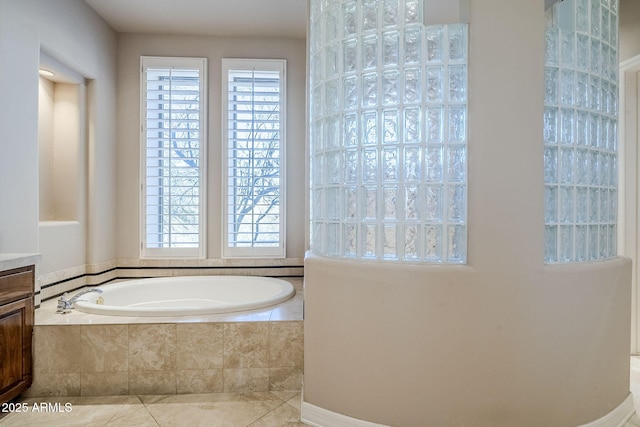 bathroom featuring vanity, tiled tub, and plenty of natural light