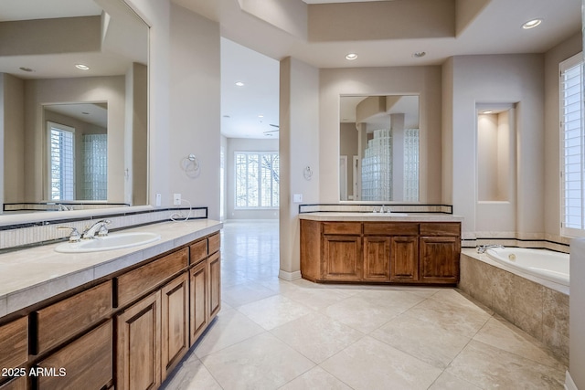 bathroom featuring vanity, tile patterned flooring, and tiled bath