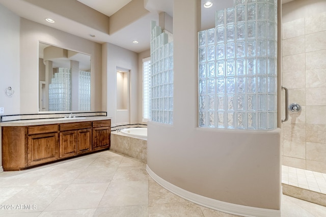 bathroom with tile patterned flooring, vanity, and shower with separate bathtub