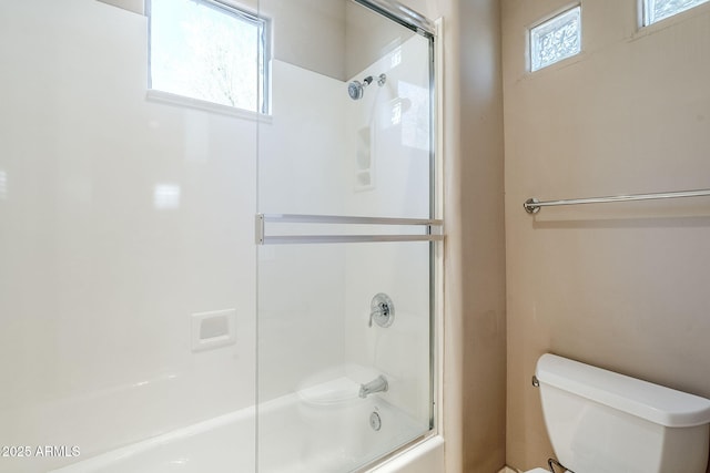 bathroom with enclosed tub / shower combo and toilet