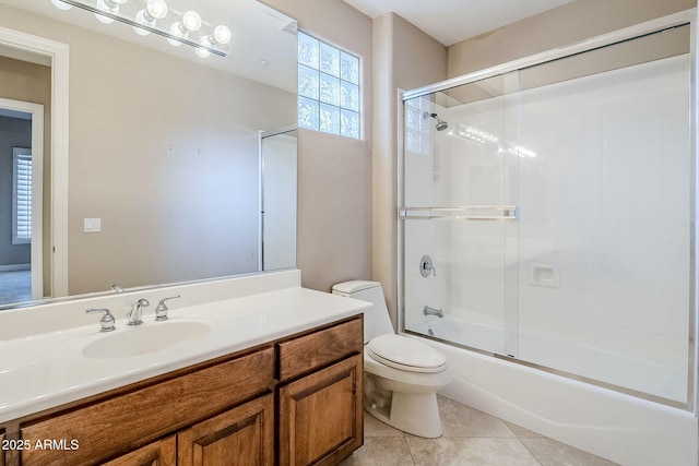 full bathroom featuring vanity, tile patterned floors, shower / bath combination with glass door, and toilet