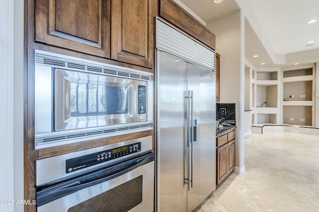 kitchen featuring built in shelves, built in appliances, and light tile patterned flooring