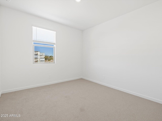 spare room with carpet and baseboards