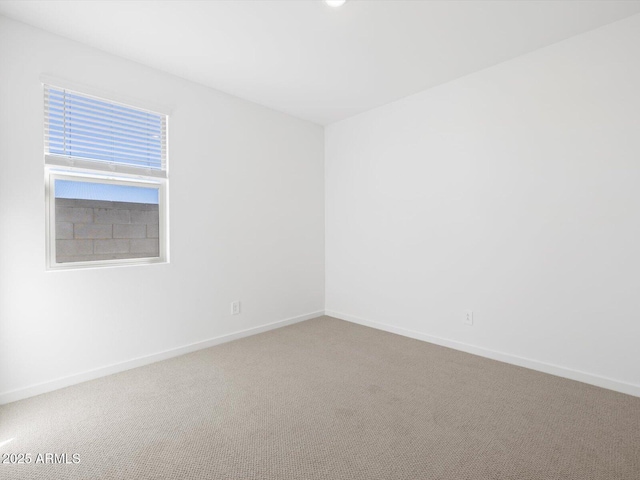 unfurnished room with baseboards and carpet flooring