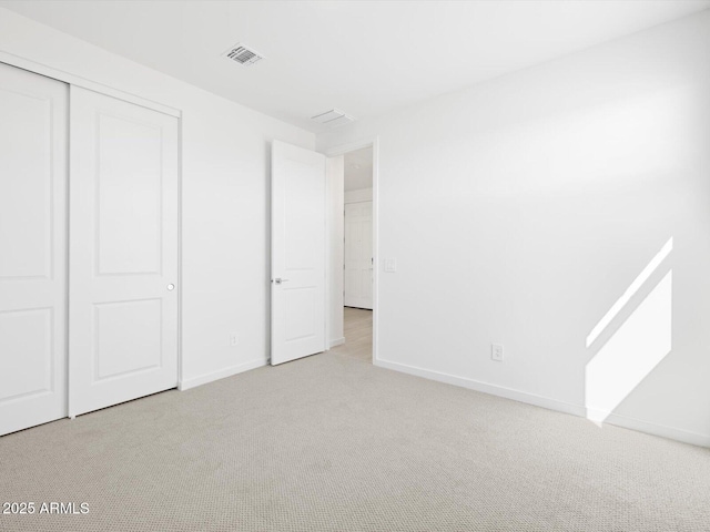 unfurnished bedroom featuring carpet, visible vents, baseboards, and a closet