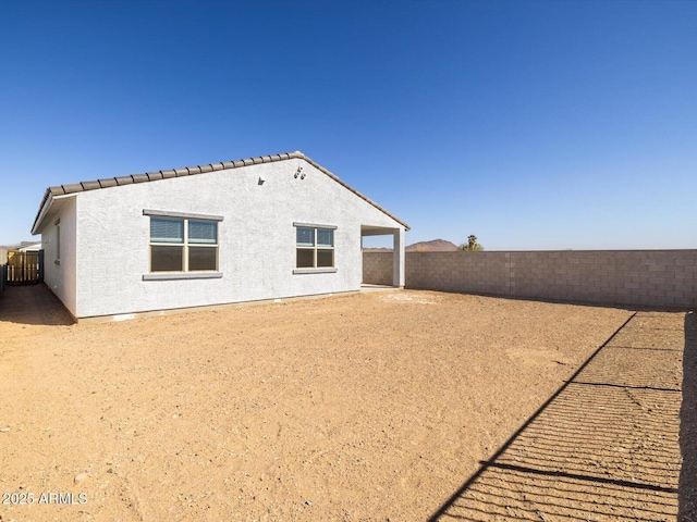 back of property with a fenced backyard and stucco siding