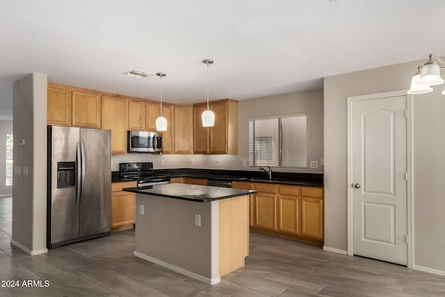 kitchen with sink, a center island, appliances with stainless steel finishes, and decorative light fixtures