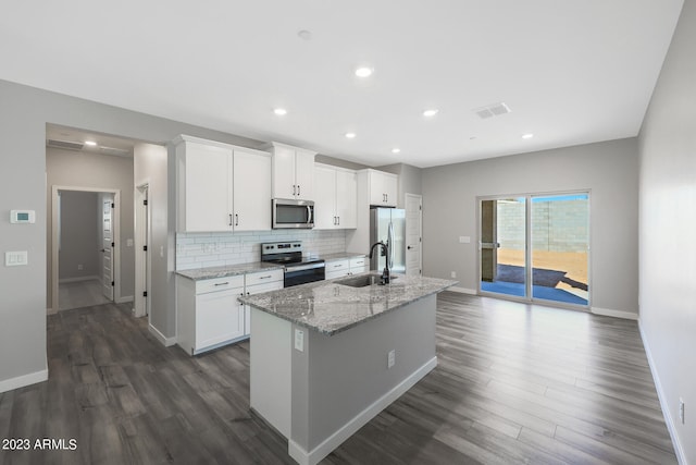 kitchen featuring tasteful backsplash, a kitchen island with sink, stainless steel appliances, white cabinetry, and a sink