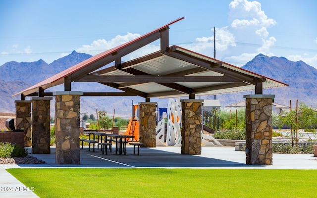 view of home's community with a mountain view and a yard
