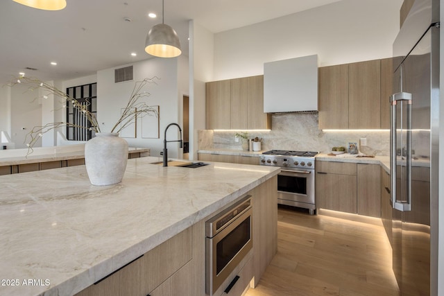13631 E Windrose Dr, Scottsdale, AZ 85259 - kitchen with high end appliances, a sink, light brown cabinetry, modern cabinets, and wall chimney exhaust hood