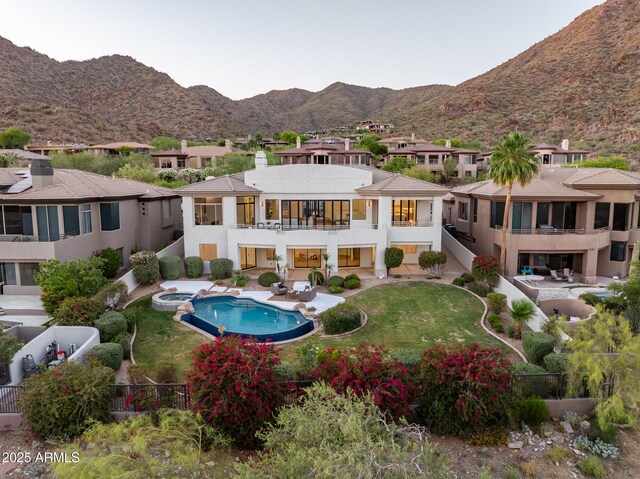 13631 E Windrose Dr, Scottsdale, AZ 85259 - back of property with a balcony, a mountain view, a pool with connected hot tub, a patio, and a residential view