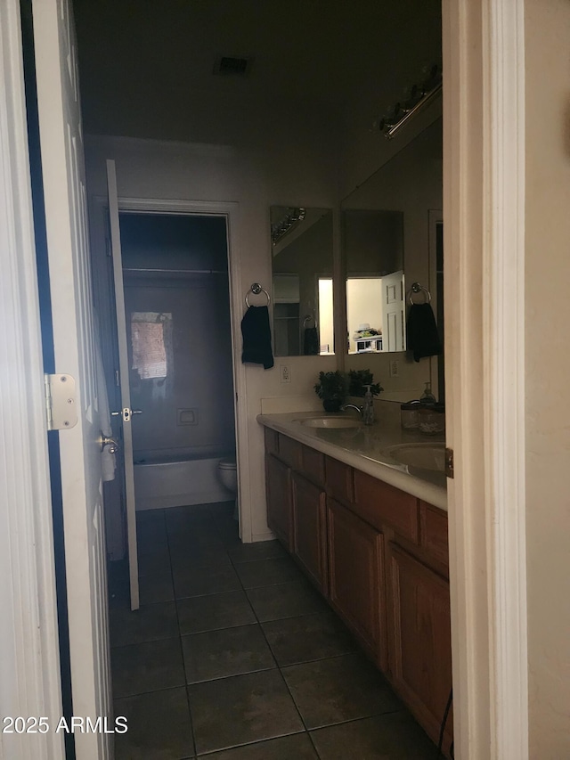 bathroom with a tub to relax in, tile patterned flooring, vanity, and toilet