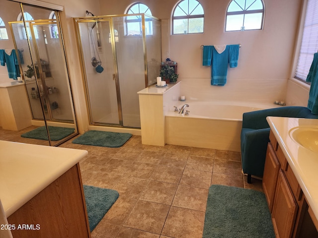 bathroom featuring tile patterned flooring, shower with separate bathtub, and vanity