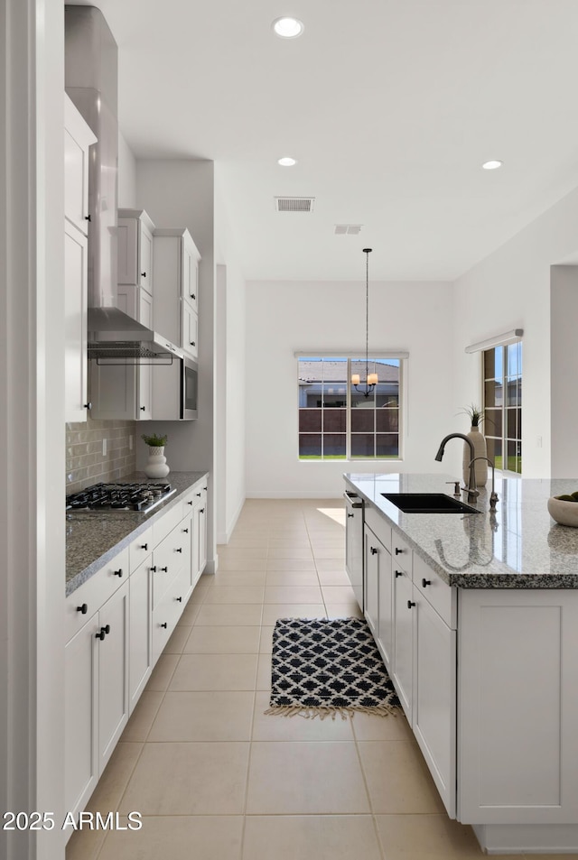 27908 N 38th Dr, Phoenix, AZ 85083 - kitchen featuring wall chimney exhaust hood, stainless steel appliances, a sink, tasteful backsplash, and a notable chandelier
