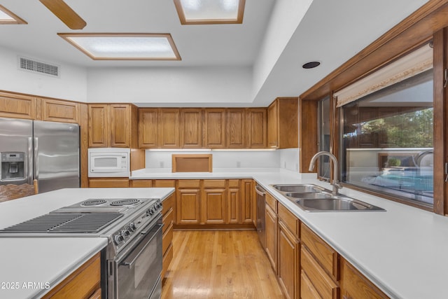 8604 S Oak St, Tempe, AZ 85284 - kitchen with appliances with stainless steel finishes, light countertops, light wood finished floors, and brown cabinetry