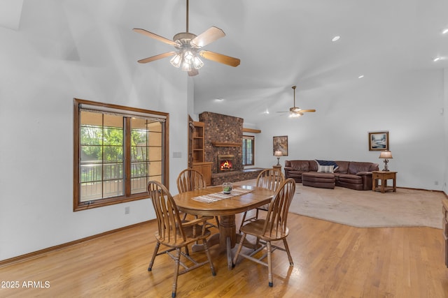 8604 S Oak St, Tempe, AZ 85284 - dining area featuring ceiling fan, a large fireplace, light wood-style floors, and high vaulted ceiling