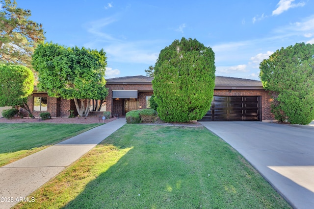 8604 S Oak St, Tempe, AZ 85284 - view of property hidden behind natural elements featuring a garage, brick siding, concrete driveway, and a front lawn