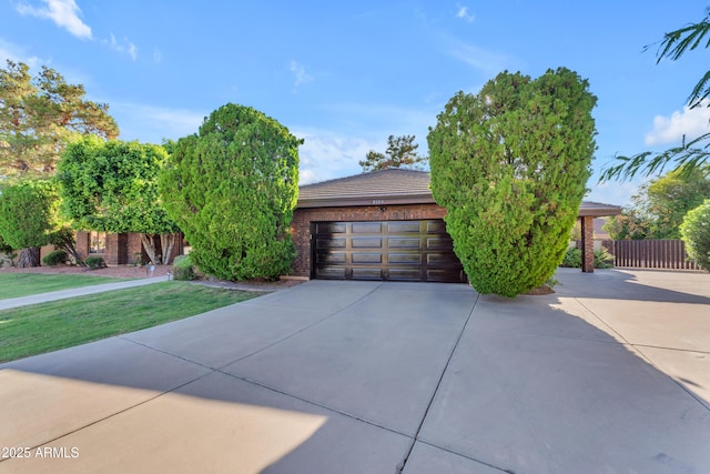 8604 S Oak St, Tempe, AZ 85284 - view of property hidden behind natural elements featuring driveway, an attached garage, and brick siding