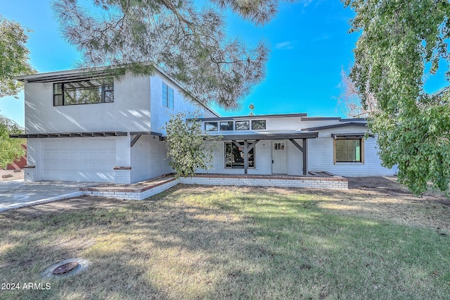 view of front of property featuring a garage and a front lawn