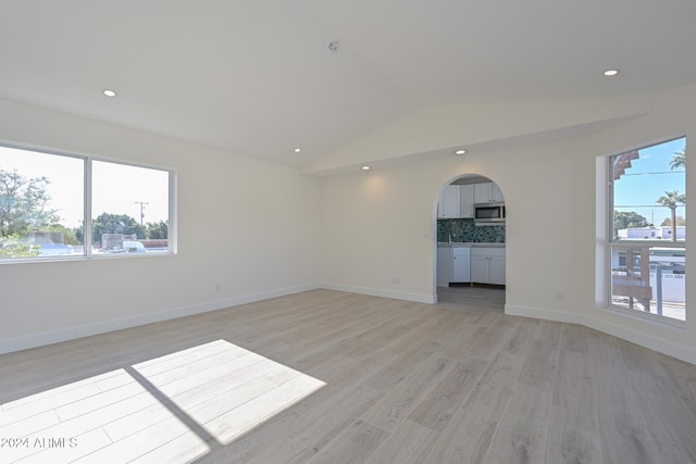 6312 N 13th St, Phoenix, AZ 85014 - spare room featuring lofted ceiling, light wood-type flooring, arched walkways, baseboards, and recessed lighting
