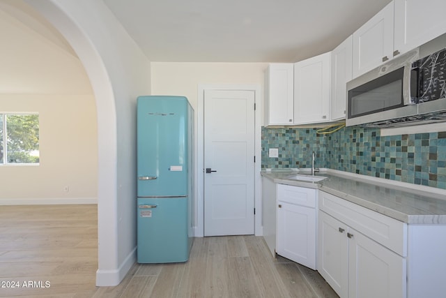 6312 N 13th St, Phoenix, AZ 85014 - kitchen with refrigerator, stainless steel microwave, a sink, and light wood-style flooring