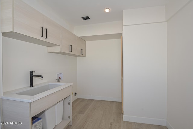 6312 N 13th St, Phoenix, AZ 85014 - washroom featuring cabinet space, washer hookup, light wood-style floors, baseboards, and recessed lighting
