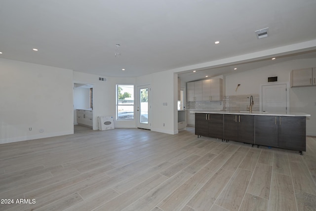 6312 N 13th St, Phoenix, AZ 85014 - unfurnished living room featuring a sink, light wood-style flooring, recessed lighting, and baseboards