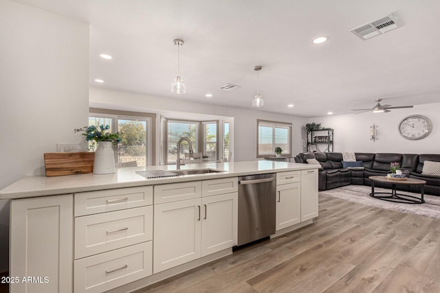 kitchen with stainless steel dishwasher, light hardwood / wood-style flooring, ceiling fan, decorative light fixtures, and sink