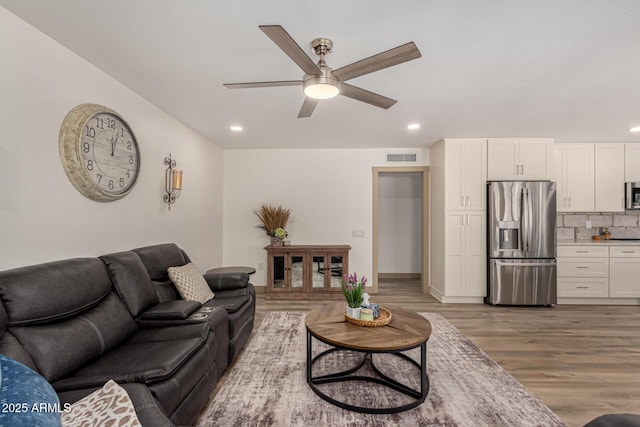 living room with hardwood / wood-style flooring and ceiling fan