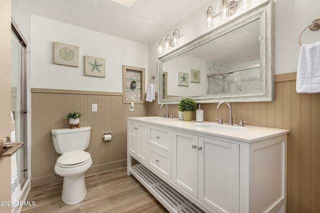 bathroom featuring hardwood / wood-style floors, toilet, walk in shower, and vanity