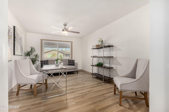 living area with ceiling fan and hardwood / wood-style floors