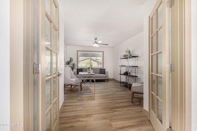 sitting room with hardwood / wood-style floors, ceiling fan, and french doors