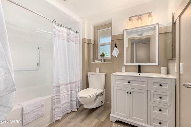 full bathroom with vanity, toilet, hardwood / wood-style floors, and shower / tub combo