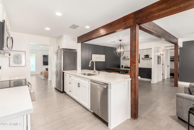 3038 E Avalon Dr, Phoenix, AZ 85016 - kitchen featuring appliances with stainless steel finishes, a sink, open floor plan, beamed ceiling, and white cabinetry