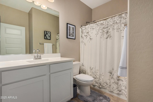 bathroom featuring toilet, vanity, and tile patterned flooring