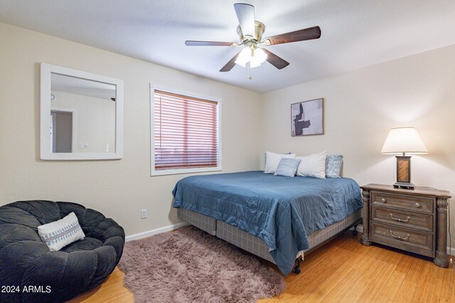 bedroom with light hardwood / wood-style flooring and ceiling fan