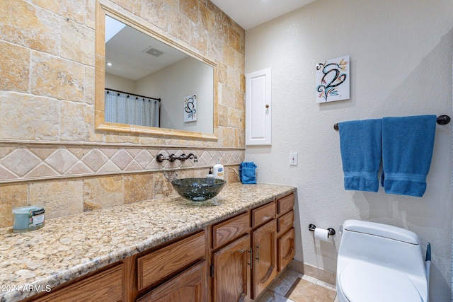 bathroom featuring tile walls, vanity, and toilet